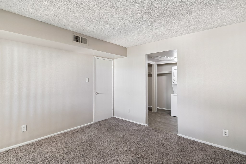 an empty living room with white walls and a carpeted floor